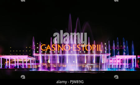 Fassade des Casino Estoril mit bunten Brunnen Show am Abend, eines der größten Casinos in Europa und eine Inspiration für Ian Fleming's 007 Stockfoto