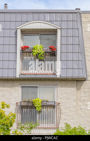Apartment Gebäude Balkone mit einigen interessanten architektonischen Details und bunten Pflanzmaschine Boxen. Stockfoto