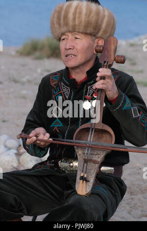 Issyk Kul, Kirgisistan/Mai 28, 2017 - Musiker spielt traditionelle Komuz bundlosen Saiteninstrument Stockfoto