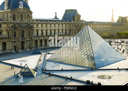 Menschen zu Fuß in der Nähe der gläsernen Pyramide im Louvre, Paris, Frankreich. Stockfoto