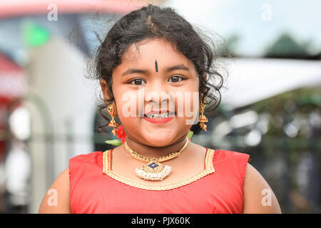 Lewisham, London, 9. September 2018. Ein kleines Mädchen lächelt, während sie die Prozession beobachtet. Mehrere tausend Gläubige und Besucher feiern das Tamil Chariot Festival rund um den Londoner Sivan Kovil Tempel mit einer Prozession durch das Stadtzentrum von Lewisham in London. Quelle: Imageplotter News und Sports/Alamy Live News Stockfoto