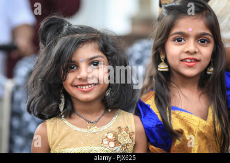 Lewisham, London, 9. September 2018. Zwei Mädchen lächeln, während sie die Prozession beobachten. Mehrere tausend Gläubige und Besucher feiern das Tamil Chariot Festival rund um den Londoner Sivan Kovil Tempel mit einer Prozession durch das Stadtzentrum von Lewisham in London. Quelle: Imageplotter News und Sports/Alamy Live News Stockfoto