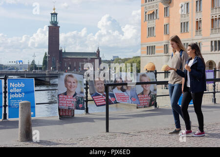 Stockholm, Schweden, 9. September, 2018. Leute, die durch die Banner der Kandidaten während der schwedischen Parlamentswahl 2018. An diesem Tag die Mitglieder des Reichstags gewählt werden, und die regionalen und kommunalen Wahlen sind noch am gleichen Tag Kredit: StockphotoVideo/Alamy Leben Nachrichten gehalten Stockfoto