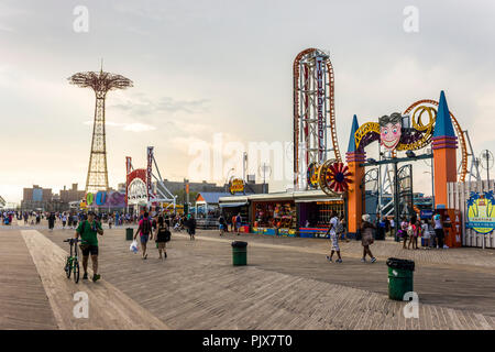 New York City. Blick auf Coney Island Promenade oder Riegelmann Boardwalk an einem langen Sommertag, mit dem Fallschirm springen und die Thunderbolt in Luna Park Stockfoto