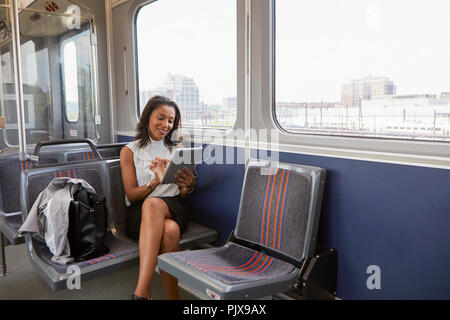 Geschäftsfrau mit digital-Tablette auf dem Zug Stockfoto