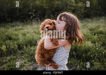 Welpen vom Mädchen küsse drehen Stockfoto