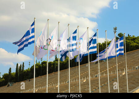 Flaggen von Griechenland und Flaggen der Olympischen Spiele wave außerhalb von Panathenaic Stadion in Athen, Griechenland, am 18. Juli 2018 Stockfoto