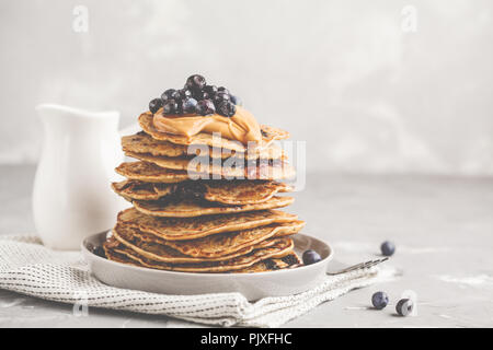 Stapel vegan Blueberry Pancakes mit Erdnussbutter und Sirup. Saubere Konzept essen. Stockfoto