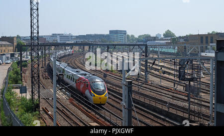 London, England - Mai 28, 2018: A Virgin Rail Gruppe Personenzug in Richtung Norden auf der Primrose Hill, eine kurze Entfernung außerhalb der Euston Hauptbahnhof Stockfoto