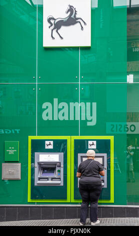 Dame mit einem Lloyds Bank Geldautomat, Bristol, England, Großbritannien Stockfoto