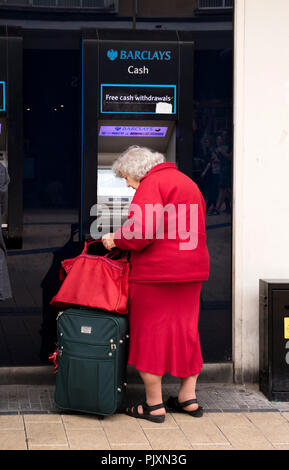 Ältere Dame mit einem Barclays Bank, Geldautomat, Bristol, England, Großbritannien Stockfoto