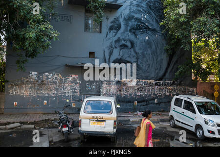 Frau geht Vergangenheit Wandbild an der Seite des Gebäudes in Lodhi Kolonie lackiert, Neu Delhi, Indien Stockfoto