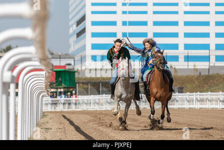 See Issyk-Kul, Kurgyzstan, 6. September 2018: Spiel des Kyz Kuu, wo Guy neds eine Dame auf einem Pferd zu fangen und gib ihr einen Kuss Stockfoto