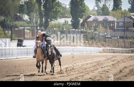 See Issyk-Kul, Kurgyzstan, 6. September 2018: Spiel des Kyz Kuu, wo Guy neds eine Dame auf einem Pferd zu fangen und gib ihr einen Kuss Stockfoto