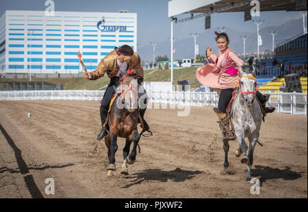 See Issyk-Kul, Kurgyzstan, 6. September 2018: Spiel des Kyz Kuu, wo Guy neds eine Dame auf einem Pferd zu fangen und gib ihr einen Kuss Stockfoto