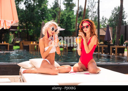 Angenehme junge Frauen genießen ihre leckere Cocktails Stockfoto
