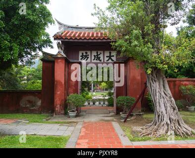 Traditionelle chinesische Eingang zu einem Park. Alter Baum und rotem Stein gepflasterten Weg im Vordergrund Stockfoto