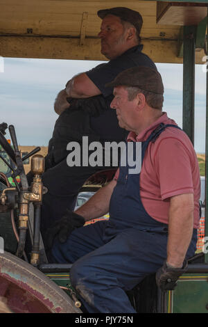 Dampf Enthusiasten auf einem großen Zugmaschine oder Dampfwalze in einem Land Dampf- und Landwirtschaftsmesse. Stockfoto