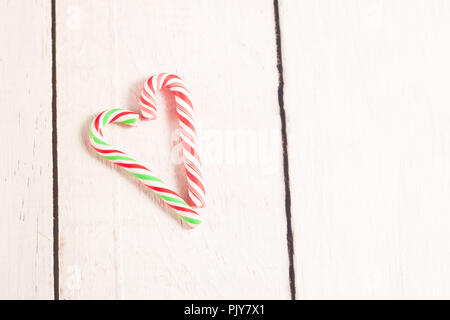 Herzförmige Zuckerstangen auf weißen Holzmöbeln rustikal Schreibtisch. Stockfoto