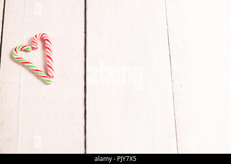 Herzförmige Zuckerstangen auf weißen Holzmöbeln rustikal Schreibtisch. Stockfoto