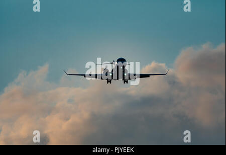 Hoher Kontrast von Jet Flug mit ausgefahrenem Fahrwerk Stockfoto