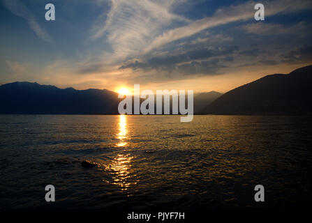 Sonnenuntergang über einem Alpinen See Maggiore mit Berg in Locarno, Schweiz. Stockfoto