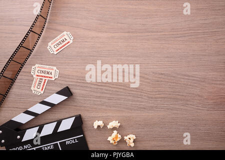 Geräte und Elemente des Kinos auf hölzernen Tisch. Konzept der Filme. Vertikale Komposition. Ansicht von oben. Stockfoto