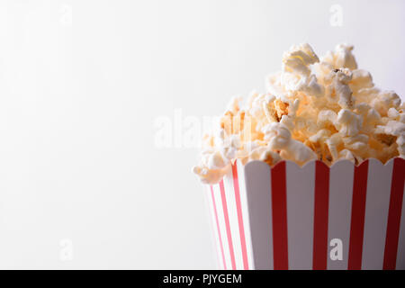 Popcorn im Karton mit weißen Hintergrund. Horizontale Komposition. Vorderansicht. Stockfoto