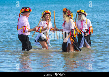 Swanage, Dorset, Großbritannien. 9. September 2018. Menschenmassen strömen zu den zweiten Tag der Swanage Folk Festival der Tanzgruppen und Musik entlang der Küste zu sehen. Herrlich warme sonnige Wetter lockte einige Tänzer im Meer, am Ende einer wunderschönen Wochenende zu tanzen. Morris Dancers, Mitglieder von Phoenix Morris tanzen im Meer. Credit: Carolyn Jenkins/Alamy leben Nachrichten Stockfoto