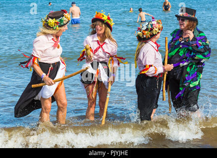 Swanage, Dorset, Großbritannien. 9. September 2018. Menschenmassen strömen zu den zweiten Tag der Swanage Folk Festival der Tanzgruppen und Musik entlang der Küste zu sehen. Herrlich warme sonnige Wetter lockte einige Tänzer im Meer, am Ende einer wunderschönen Wochenende zu tanzen. Morris Dancers, Mitglieder von Phoenix Morris tanzen im Meer mit Mitglied von Wicket Brut Grenze Morris. Credit: Carolyn Jenkins/Alamy leben Nachrichten Stockfoto