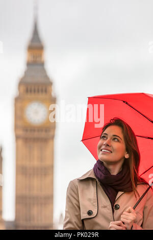Mädchen oder Junge Frau Tourist im Urlaub mit einem roten Regenschirm mit Big Ben im Hintergrund, London, England, Großbritannien Stockfoto