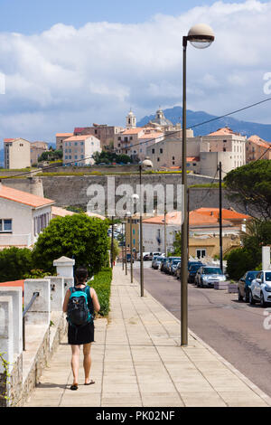 Tourist mit Rucksack zu Fuß in Richtung Calvi Zitadelle. Calvi, Korsika, Frankreich Stockfoto