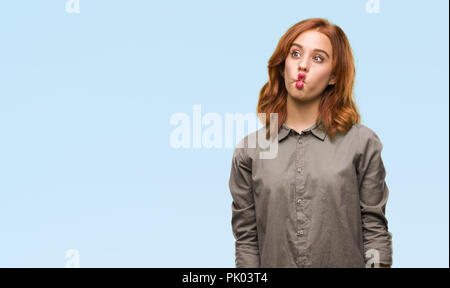 Junge schöne Frau über isolierte, Fisch Gesicht mit Lippen, verrückt und komische Geste. Lustige Ausdruck. Stockfoto