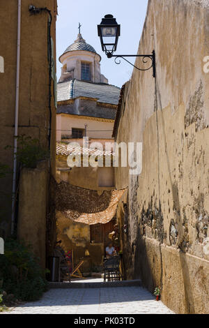 Durch die schmale Gasse in Richtung Saint-Jean Baptiste Kathedrale in der Zitadelle von Calvi, Korsika, Frankreich Stockfoto