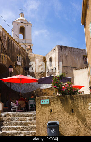 Outdoor Restaurant Terrasse mit Turm der Kathedrale im Hintergrund, die Zitadelle von Calvi, Korsika, Frankreich Stockfoto