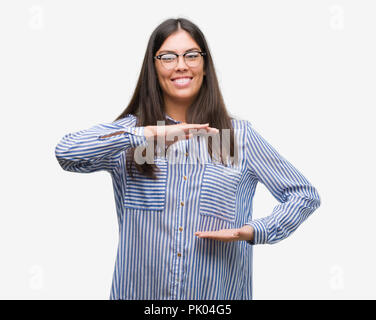 Junge schöne Hispanic Business woman gestikulierte mit Händen zeigen große und große Zeichen, Symbol. Lächelnd in die Kamera schaut. Messung Stockfoto