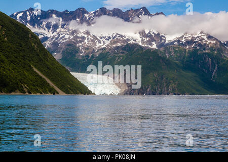 Ansicht der Aialik Gletscher in der Aialik Bay, Alaska, USA. Wasser im Vordergrund, Green mountain glacier Links, Schnee auf den Bergen auf der rechten, blauen Himmel. Stockfoto