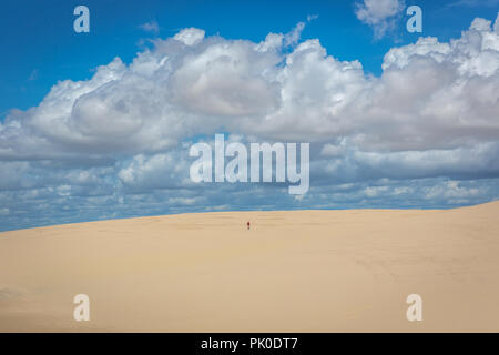 Einsamer Mann gehen durch einen weiten und leeren, weißen Sand dune im Norden Brasiliens Stockfoto