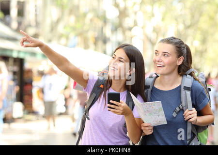 Zwei glückliche Backpackers Sightseeing in einer großen Stadt Straße an Sehenswürdigkeiten zeigen Stockfoto