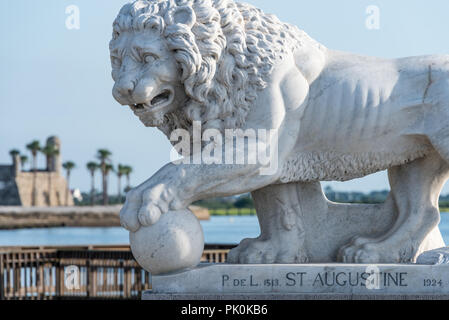 Aus weißem Carrara-Marmor lion Statue auf St. Augustine, Florida's Bridge of Lions über Matanzas Bay, mit dem Castillo de San Marcos fort im Hintergrund. (USA) Stockfoto