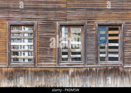 Bis windows bestieg auf verwitterte Holz- wand der abgebrochenen alten Gebäude Stockfoto