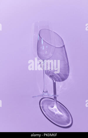 Wein Glas, die in eine kurze wie ein Schatten über einem violetten Hintergrund zusammen mit den Schatten Stockfoto