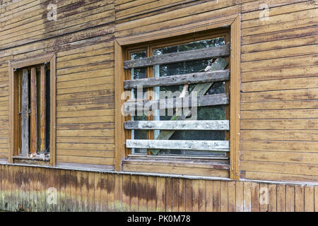 Mauer der alten heruntergekommenen Gebäude aus Holz mit bis Windows an Bord Stockfoto