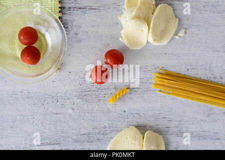 Essen Hintergrund/Cherry Tomaten, Spaghetti Pasta, Mozzarella Kugeln an den hellen Hintergrund/Konzeptionelle Bild des Kochens Abdeckung Stockfoto