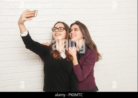 Mädchen Jugendliche gegen eine weiße Wand selfie tun Stockfoto