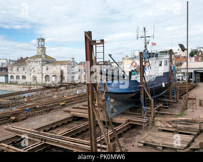 Die schiffsreparatur Helling in Ramsgate Royal Harbour, die Uhr im Hintergrund. Thanet Kent UK Stockfoto