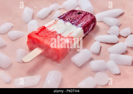 Obst Popsicle. Süße, Berry hausgemachtes Eis auf einem Stick mit Scheiben von Eis auf einem rosa Hintergrund. Sommer Dessert Stockfoto