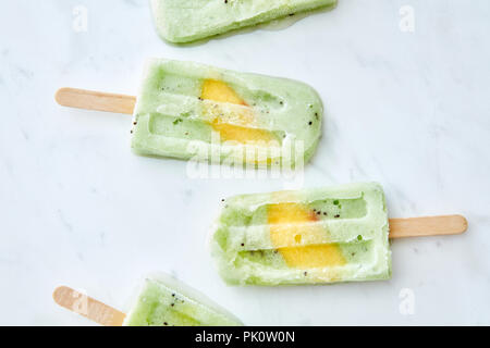 Eine Reihe von köstlichen hausgemachten berry Eis am Stiel mit einem Stück mango auf grauem Marmor tisch mit kopieren. Flach Stockfoto