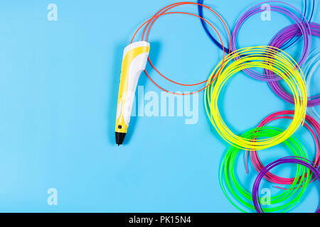 3d-pen mit bunten Kunststoff Leuchtkörper auf blauem Hintergrund Stockfoto