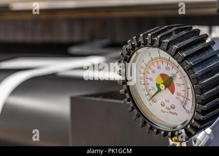 Detail einer Druckregelung Instrument in großen Druckerei. Masiven unscharfe, schwarzes Rohr im Hintergrund. Stockfoto